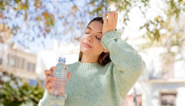 Foto mujer bonita joven con una botella de agua.