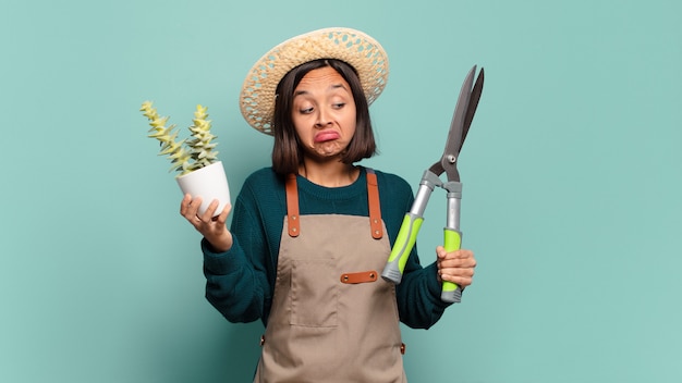 Mujer bonita joven con un cactus. concepto de granjero