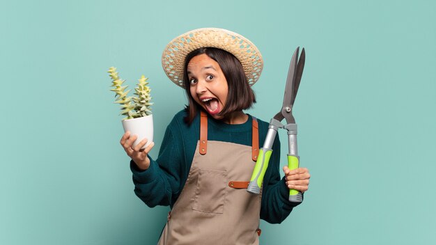 Mujer bonita joven con un cactus. concepto de granjero