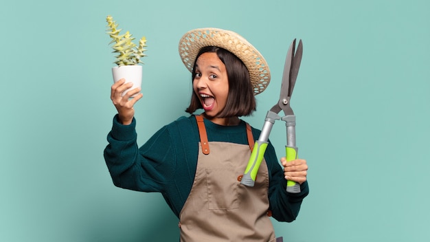 Mujer bonita joven con un cactus. concepto de granjero