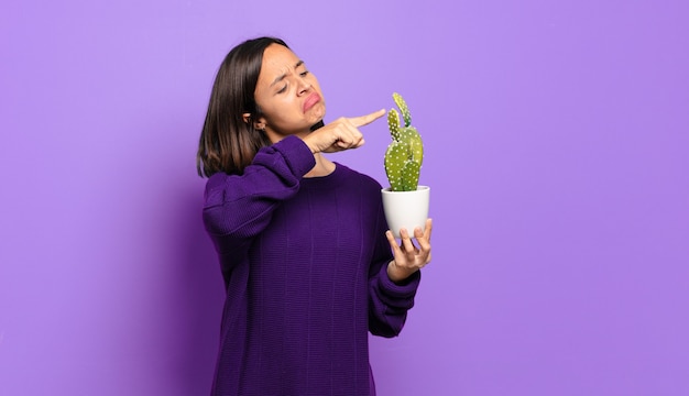 Mujer bonita joven con un cactus