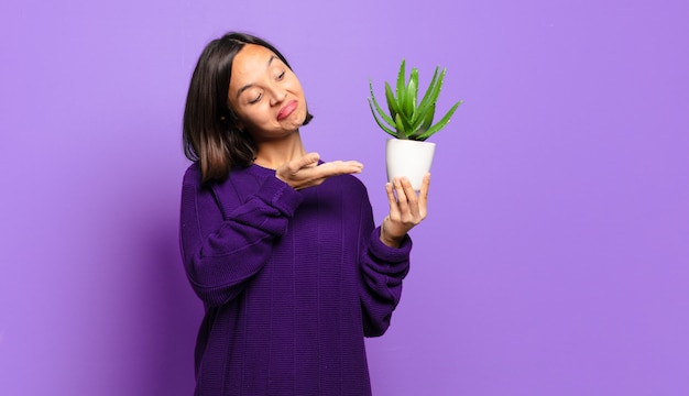 Mujer bonita joven con un cactus