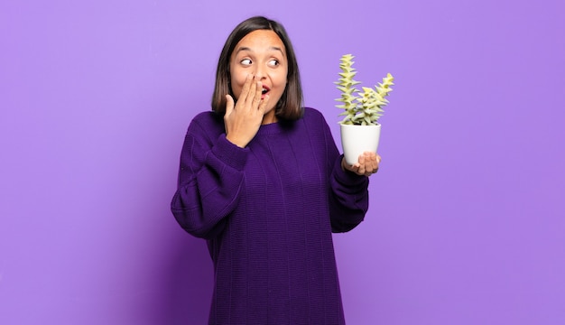 Mujer bonita joven con un cactus