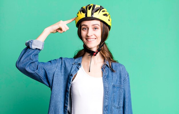 Foto mujer bonita joven con un casco de bicicleta