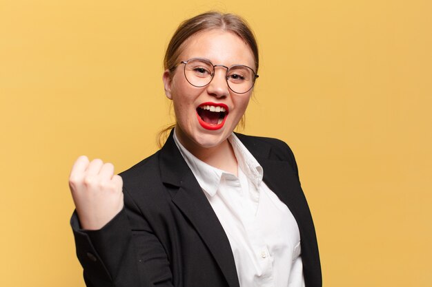 Mujer bonita joven. celebrando un triunfo como un concepto de negocio ganador