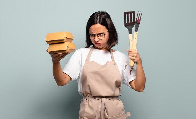 Mujer bonita joven chef. concepto de comida rapida