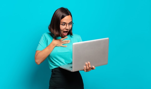 Foto mujer bonita joven con una computadora portátil