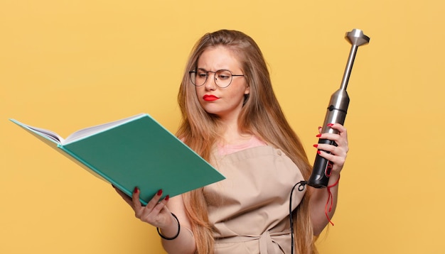 Mujer bonita joven. Concepto de licuadora de panadero de expresión de pensamiento o duda