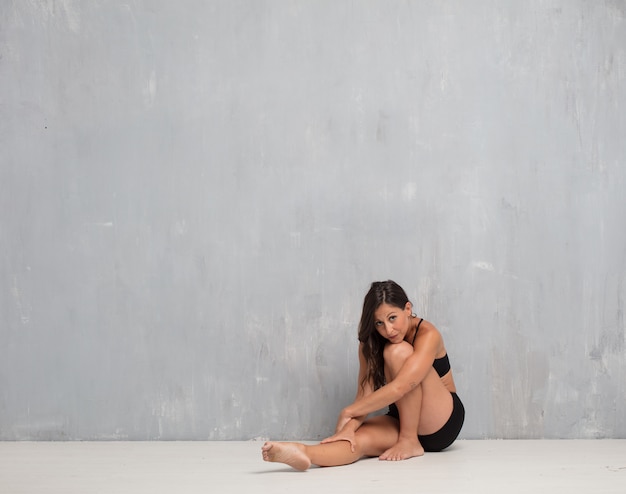 Mujer bonita joven contra fondo de la pared del cemento con un SP de la copia