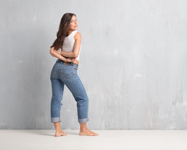 Mujer bonita joven contra fondo de la pared del cemento con un SP de la copia