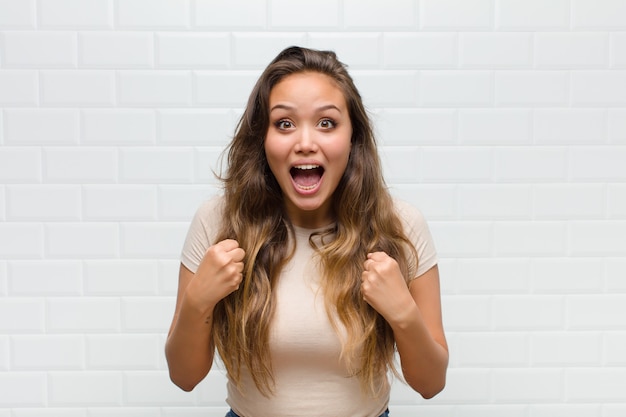 mujer bonita joven contra la pared blanca