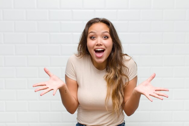 mujer bonita joven contra la pared blanca