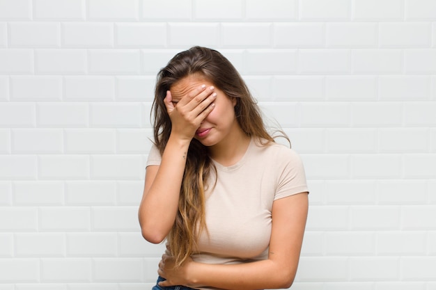 mujer bonita joven contra la pared blanca