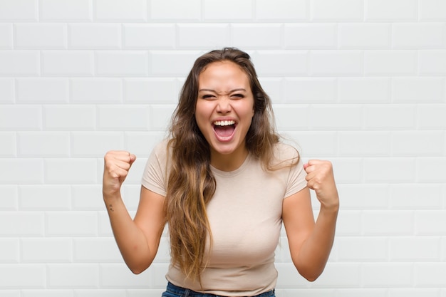 mujer bonita joven contra la pared blanca