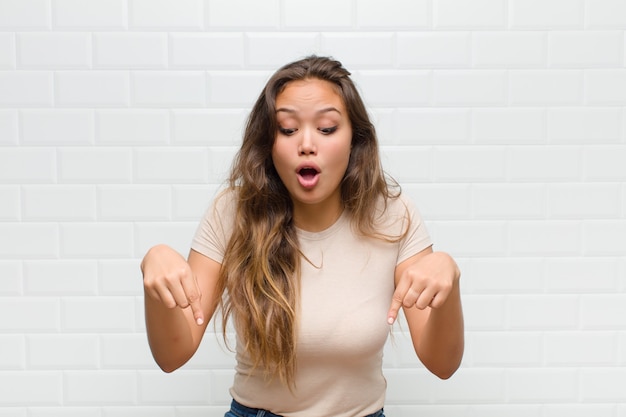 Mujer bonita joven contra la pared blanca