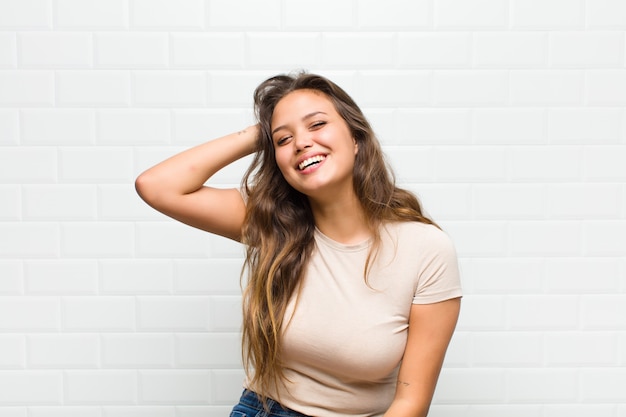 mujer bonita joven contra la pared blanca