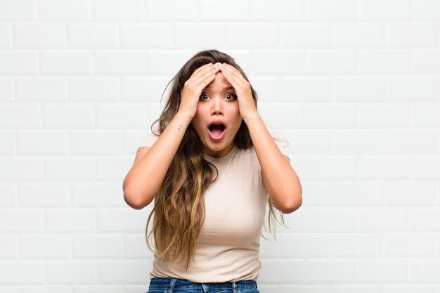 mujer bonita joven contra la pared blanca