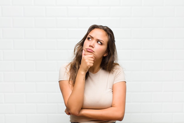 mujer bonita joven contra la pared blanca