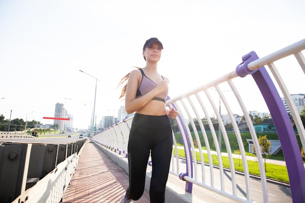 Mujer bonita joven con cuerpo delgado perfecto corriendo al aire libre. Concepto de fitness y funcionamiento.