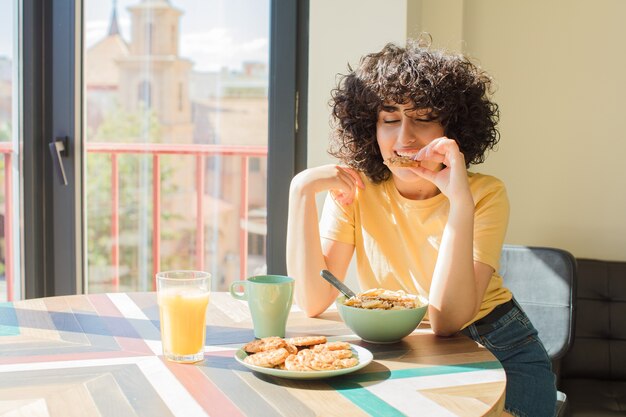 Foto mujer bonita joven desayunando en casa