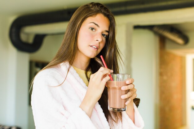 Mujer bonita joven desayunando en casa