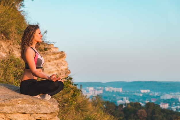 Mujer bonita joven en ejercicio de yoga al amanecer