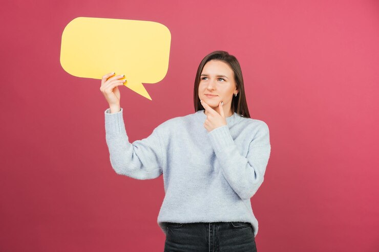 Foto mujer bonita joven está sosteniendo un discurso de burbuja amarilla mientras piensa