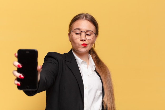 Mujer bonita joven con expresión confundida con smartphone