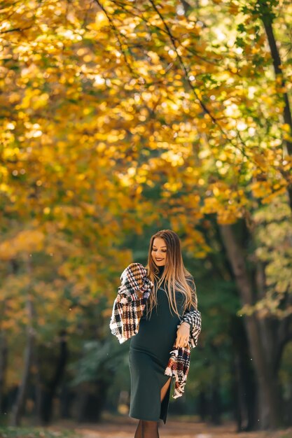 Mujer bonita joven en el fondo del parque otoño con