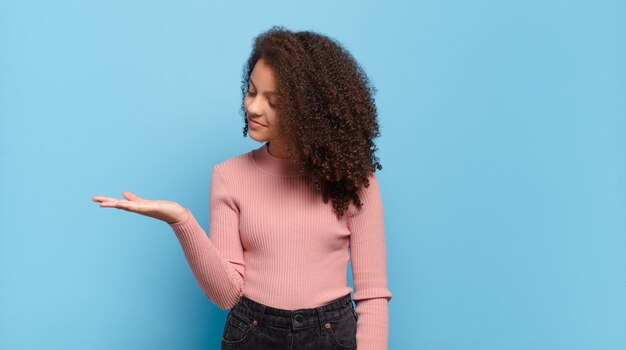 Mujer bonita joven gesticulando en la pared de color