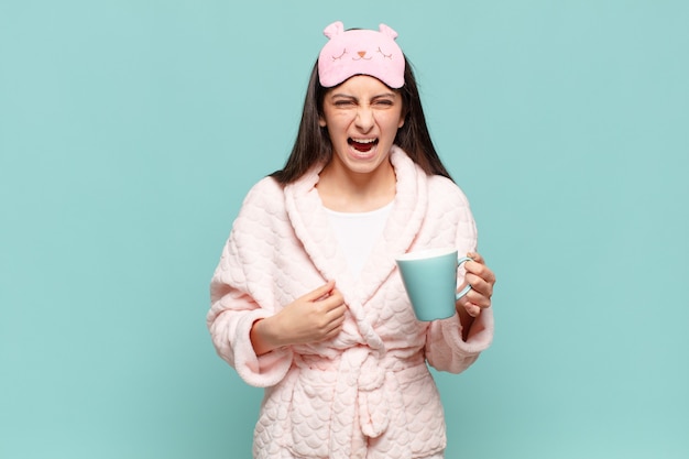 Foto mujer bonita joven gritando agresivamente, luciendo muy enojada, frustrada, indignada o molesta, gritando no. despertar vistiendo concepto de pijama