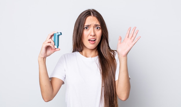 Mujer bonita joven gritando con las manos en el aire. concepto de asma