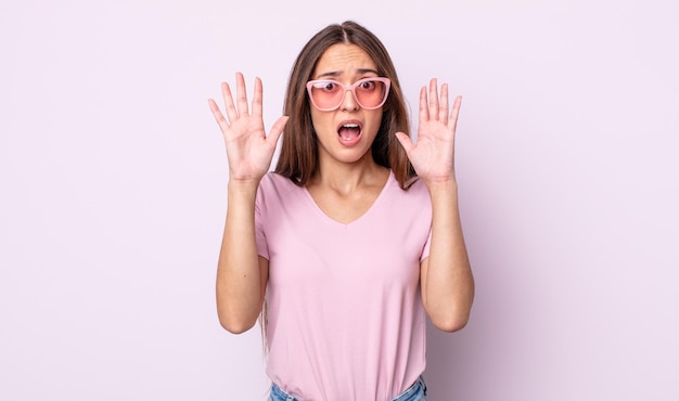 mujer bonita joven gritando con las manos en el aire. concepto de gafas de sol rosas