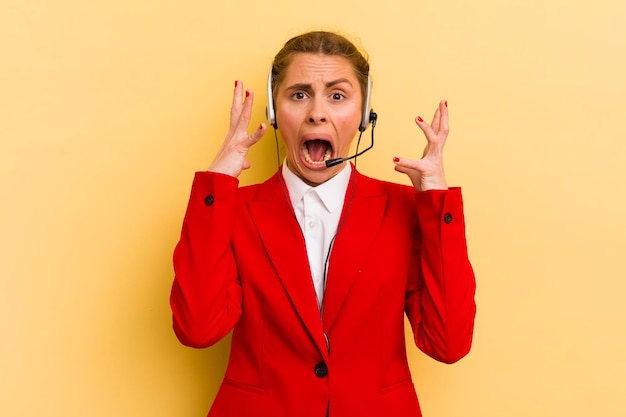 Mujer bonita joven gritando con las manos en el aire concepto de telemarketer