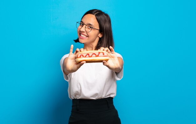 Foto mujer bonita joven con un hot dog