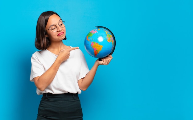 Mujer bonita joven con un mapa del mundo terráqueo