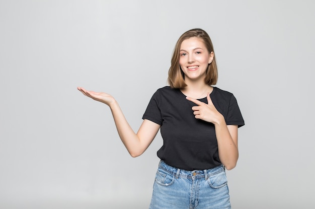 Mujer bonita joven con la palma abierta puntiaguda aislado en blanco