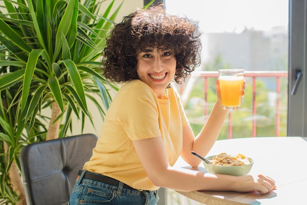 Mujer bonita joven con pelo rizado en el interior