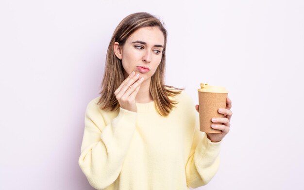 Mujer bonita joven pensando, sintiéndose dudoso y confundido. concepto de café para llevar