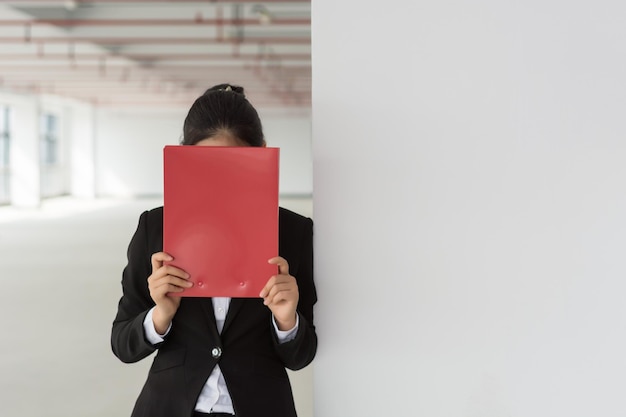 Mujer bonita joven pensativa con archivo y lápiz Mujer de negocios pensando tocar la cara con lápiz y mirando hacia otro lado Concepto de planificación Vista frontal aislada sobre fondo blanco