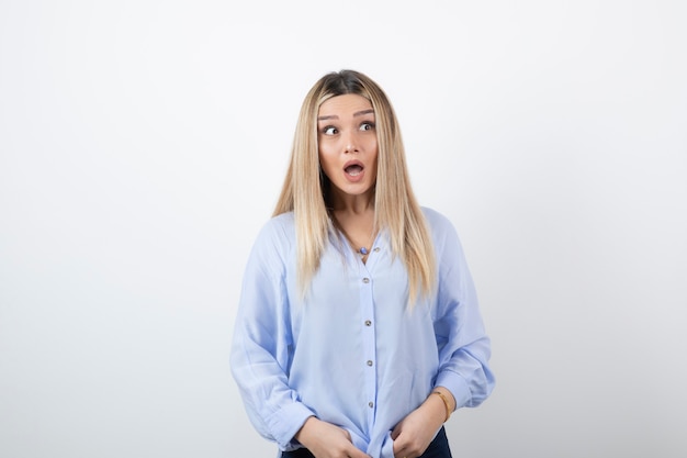 Foto mujer bonita joven de pie sobre la pared blanca.