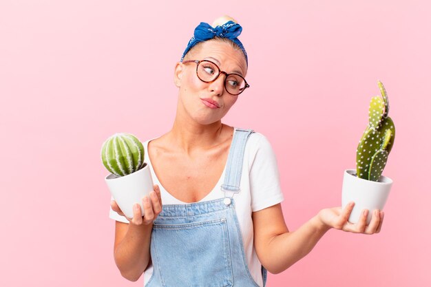 Mujer bonita joven con una planta de interior