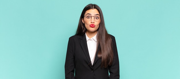 Mujer bonita joven presionando los labios con una expresión linda, divertida, feliz y encantadora, enviando un beso. concepto de negocio