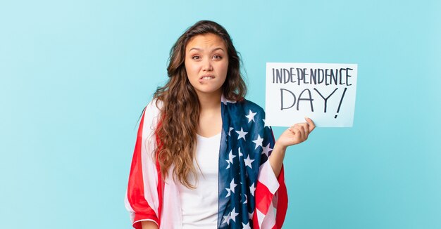 Mujer bonita joven que mira el concepto del día de la independencia desconcertado y confundido