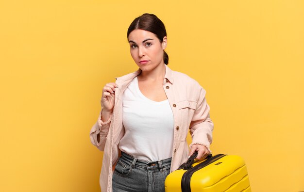 Mujer bonita joven que parece arrogante, exitosa, positiva y orgullosa, apuntando a sí misma