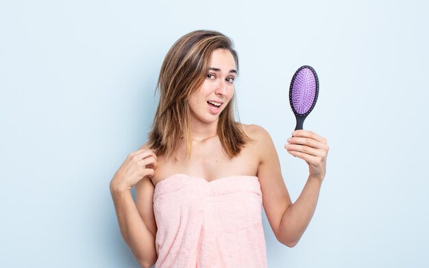 Mujer bonita joven que parece arrogante, exitosa, positiva y orgullosa. concepto de cepillo para el cabello