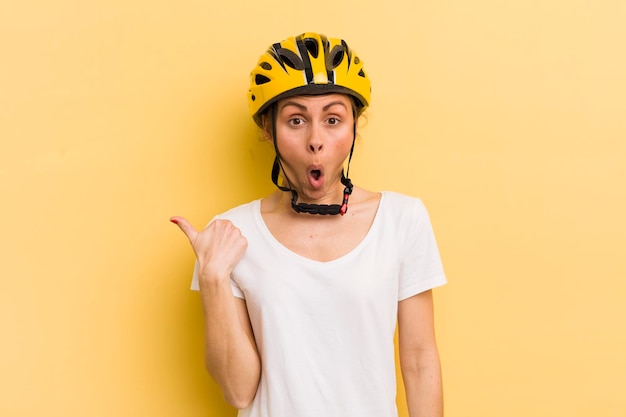 Foto mujer bonita joven que parece asombrada por el concepto de bicicleta de incredulidad