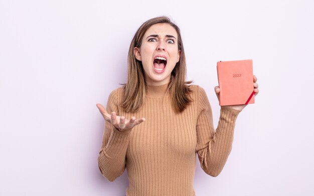 Mujer bonita joven que parece desesperada, frustrada y estresada. concepto de agenda