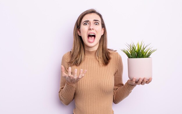 Mujer bonita joven que parece desesperada, frustrada y estresada. concepto de planta