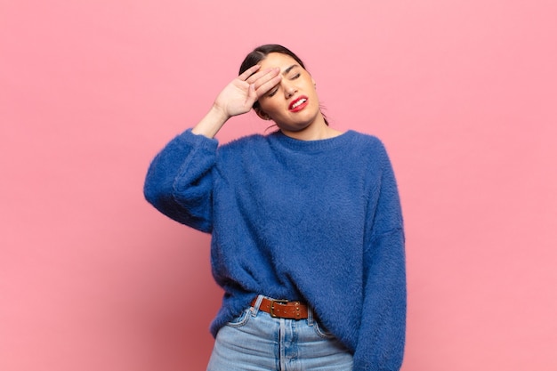 Mujer bonita joven que parece estresada, cansada y frustrada, secándose el sudor de la frente, sintiéndose desesperada y agotada